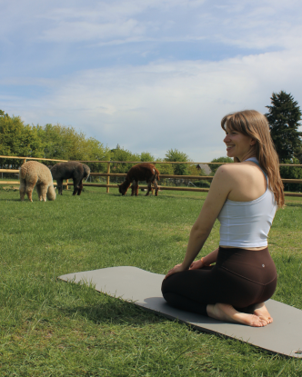 Die Yogalehrerin mit drei Alpakas im Hintergrung., © Anna Schlemmer Die Yogalehrerin mit drei Alpakas im Hintergrung., © Anna Schlemmer