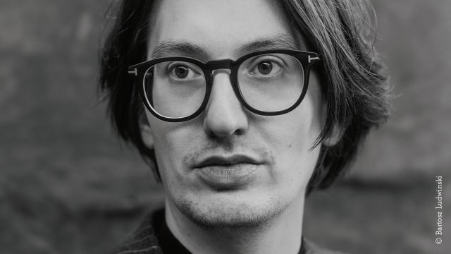 Black-and-white close-up of a male-looking person with round glasses and chin-length hair., © Bartosz Ludwinski Black-and-white close-up of a male-looking person with round glasses and chin-length hair., © Bartosz Ludwinski