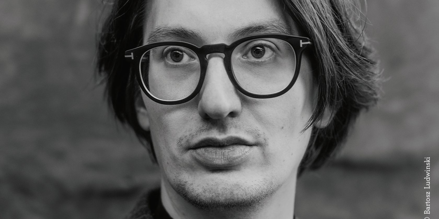 Black-and-white close-up of a male-looking person with round glasses and chin-length hair., © Bartosz Ludwinski Black-and-white close-up of a male-looking person with round glasses and chin-length hair., © Bartosz Ludwinski