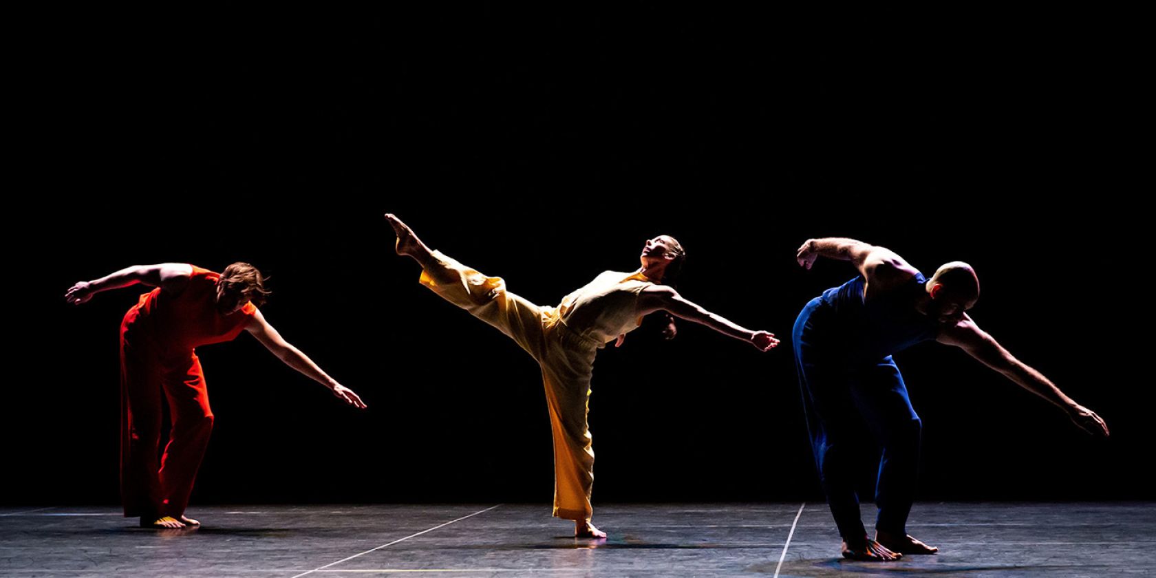 Die Performer*innen Patrick Needham, Cecily Campbell und Burr Johnson tanzen auf der B&uuml;hne, ihre Arme und Beine sind energievoll und ausdrucksstark nach au&szlig;en gestreckt., &copy; Delphine Perrin