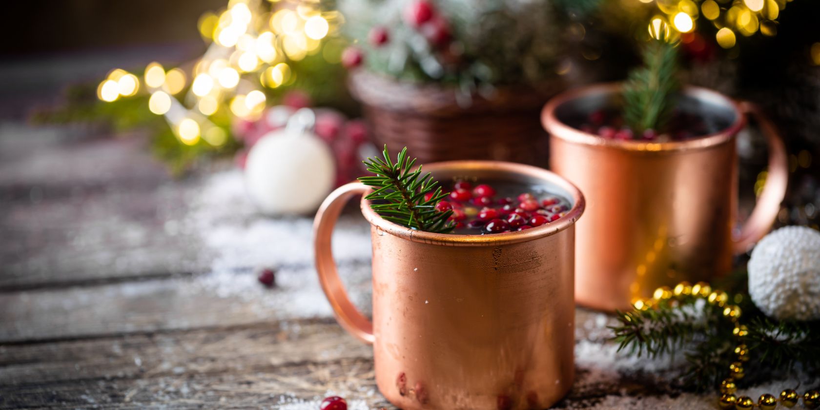 Mulled wine with cranberry in copper mug with christmas decorations on wooden table, © Petrrgoskov – stock.adobe.com“