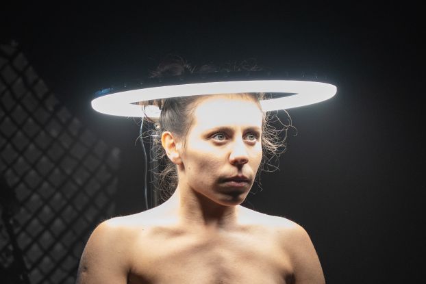 The head of a performer is surrounded by a bright circle of light., &copy; Lilia Zanetti