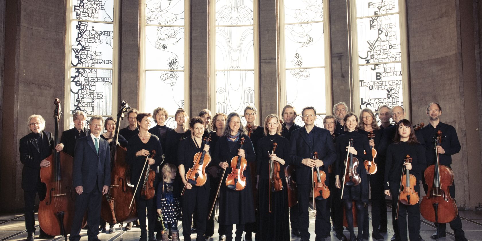 Orchesterfoto vor verzierten Fenstern, &copy; Anne de Wolff
