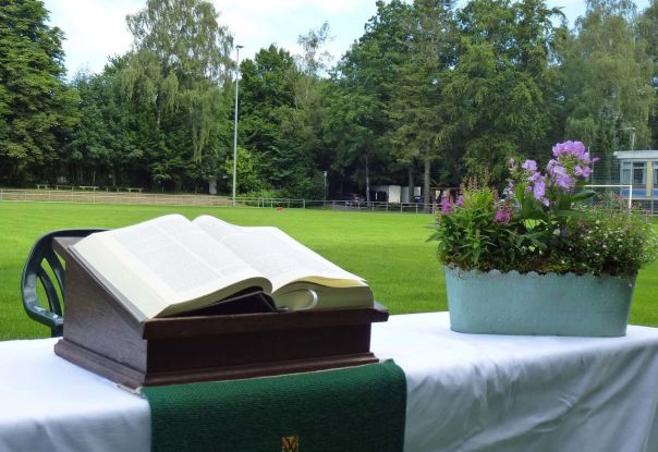 Aufgebauter Altar mit Bibel und Blumenschmuck auf einem Fu&szlig;ballfeld, &copy; Karen Diehn